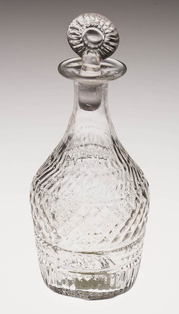 BLOWN-MOLDED GII-21 TOY DECANTER: BLOWN-MOLDED GII-21 TOY DECANTER, colorless, plain neck, plain base with rough pontil mark, appropriate pressed sunburst stopper. United States. Circa 1825-1840. 5" HOA, 3 7/8" H bottle, 1 1/2" D base