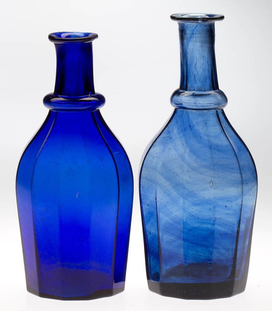 BLOWN-MOLDED PANELED CRUET OR TOILET BOTTLES, LOT OF: BLOWN-MOLDED PANELED CRUET OR TOILET BOTTLES, LOT OF TWO, deep cobalt blue and dull steel blue with unusual sapphire striations, each with 12 panels from the neck ring to the base, steel-blue example