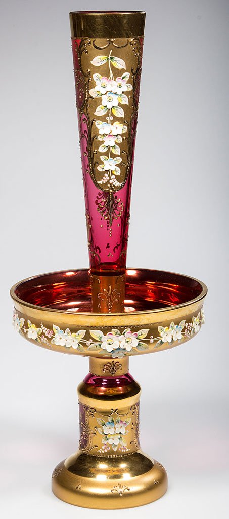 BOHEMIAN DECORATED GLASS EPERGNE: BOHEMIAN DECORATED GLASS EPERGNE, cranberry/ruby, in two sections, with polychrome-enamel impasto floral decorations within heavy gilt reserves. Czechoslovakia. Mid 20th century. 16 1/4" HOA.