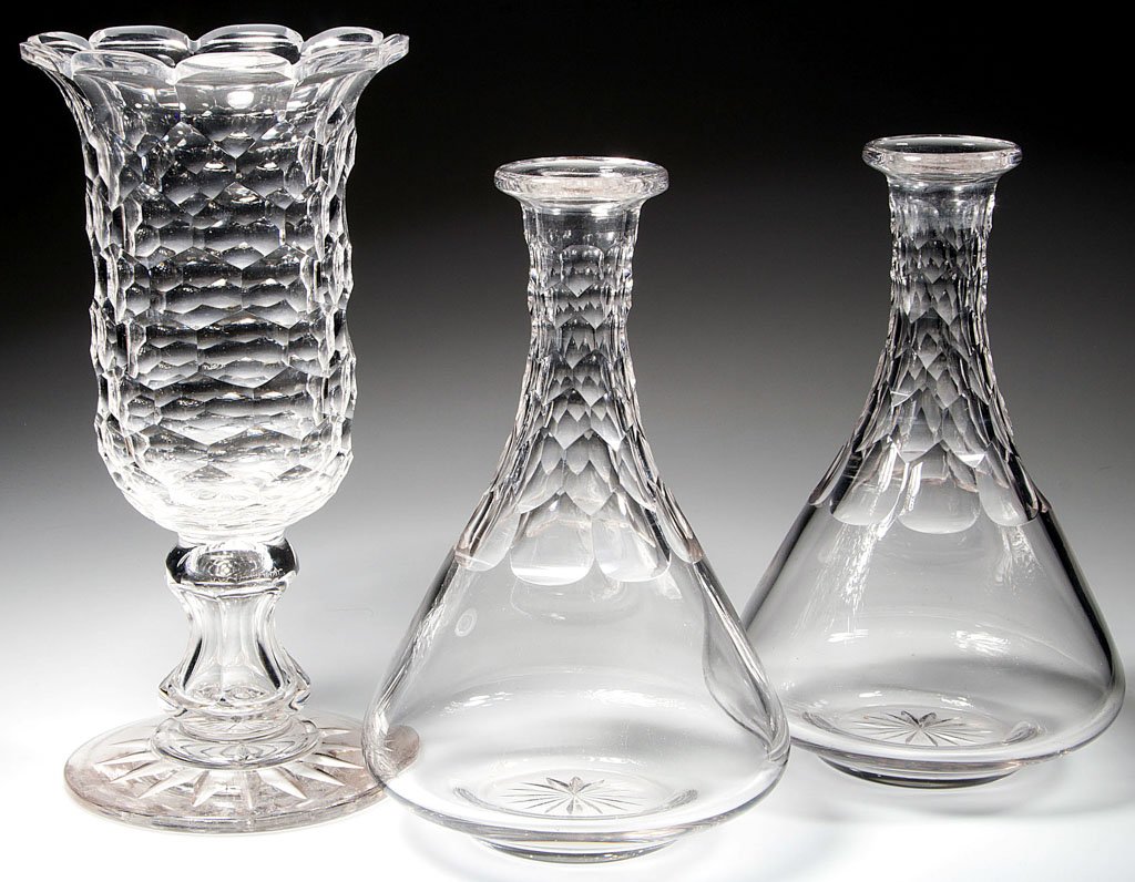 CUT HONEYCOMB TABLE ARTICLES, LOT OF THREE: CUT HONEYCOMB TABLE ARTICLES, LOT OF THREE, colorless lead glass, comprising a celery vase with hollow spool-like stem and star-cut foot, and a pair of decanters with star-cut bases, lacking stoppers.