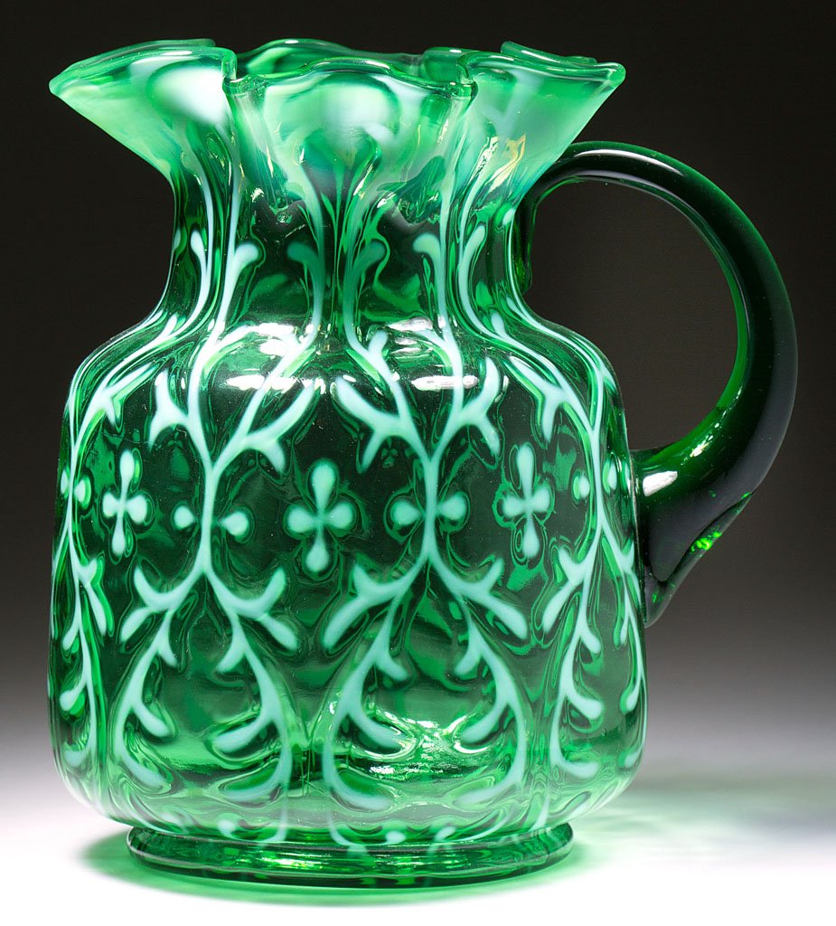 OPALINE BROCADE / SPANISH LACE WATER PITCHER: OPALINE BROCADE / SPANISH LACE WATER PITCHER, deep green opalescent, squat form with seven-point star rim, transparent green applied handle. Northwood Glass Co. Pattern introduced 1899. 8 1/2" H. Lite