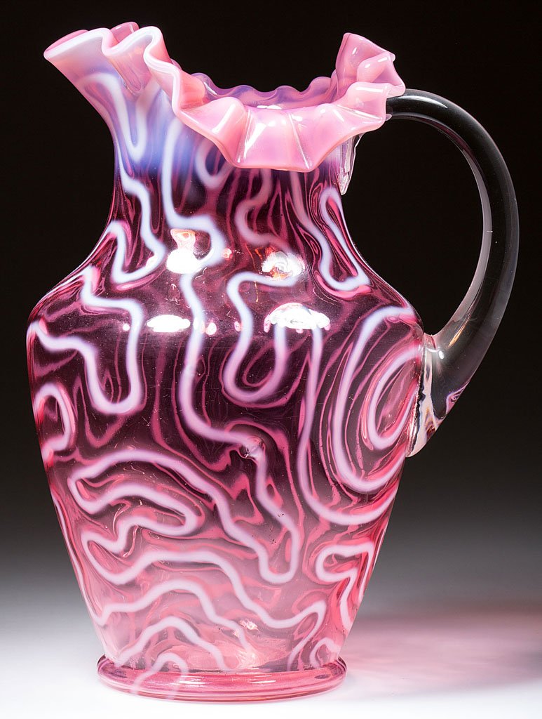 SWIRLING MAZE WATER PITCHER: SWIRLING MAZE WATER PITCHER, cranberry opalescent, shoulder form with tri-form folded and crimped rim, applied colorless handle. Jefferson Glass Co. Circa 1905. 10" HOA. Literature: Heacock/Elmore - O