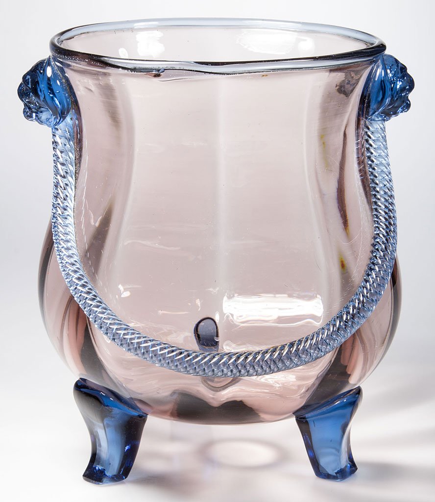 ENGLISH OR AMERICAN RIB-OPTIC VASE: ENGLISH OR AMERICAN RIB-OPTIC VASE, Smoked Crystal with applied French Blue lion-head masks, rope handle, and three feet, kettle form, polished pontil mark, not signed. Probably Stevens & Williams, po