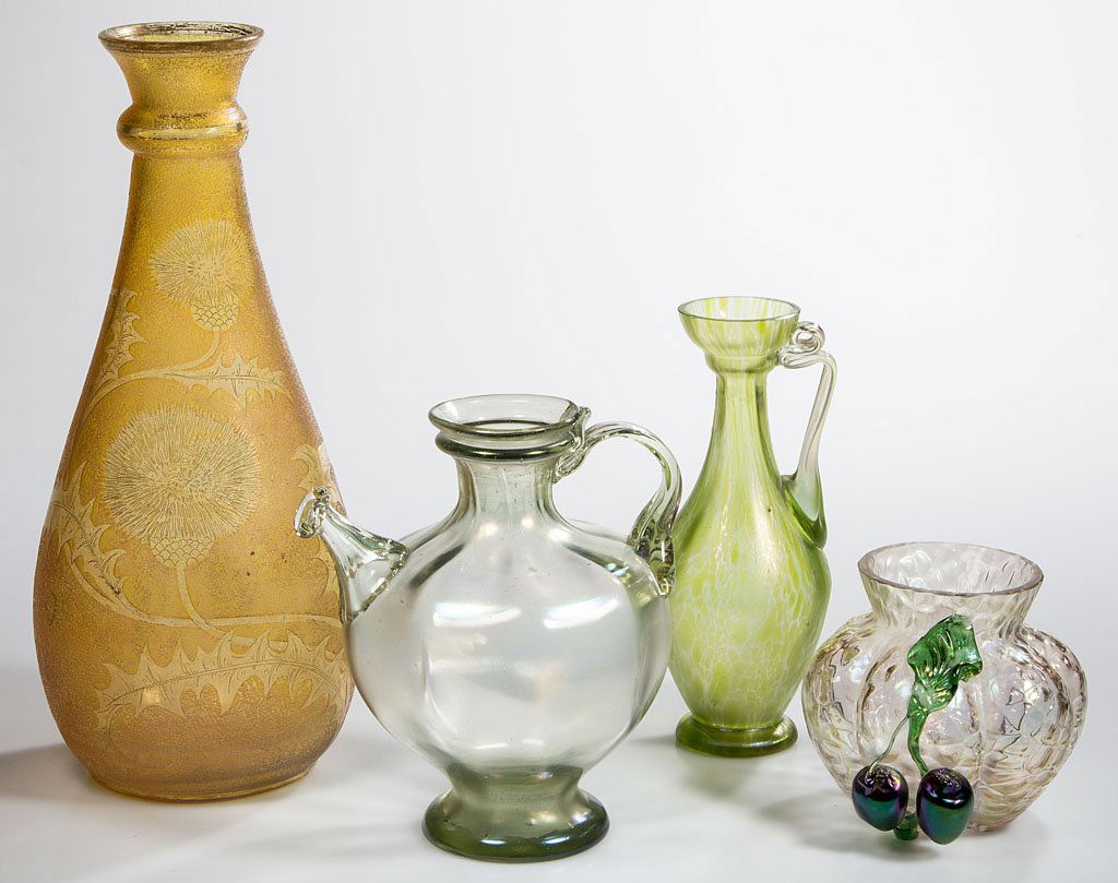 LOETZ-TYPE BOHEMIAN GLASS ARTICLES, LOT OF FOUR: LOETZ-TYPE BOHEMIAN GLASS ARTICLES, LOT OF FOUR, iridescent, comprising a Rib-Optic ancient-style oil jug, a green ewer with random oil spots, a vase with applied fruit, and a yellow vase with etched