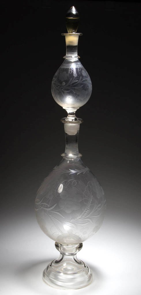BLOWN AND ENGRAVED GLASS APOTHECARY STACKING SHOW GLOBE: BLOWN AND ENGRAVED GLASS APOTHECARY STACKING SHOW GLOBE / BOTTLE, colorless, comprising two egg-form bottles with single applied neck rings and matching well-accomplished foliate engraving, with hollo