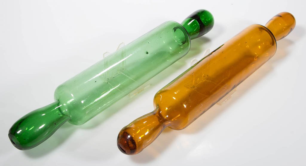 FREE-BLOWN COLORED GLASS ROLLING PINS, LOT OF TWO: FREE-BLOWN COLORED GLASS ROLLING PINS, LOT OF TWO, amber and green, green example with a ground pontil to one end. Second half 19th century. 14 1/2" H. Provenance: From a Michigan private collection.