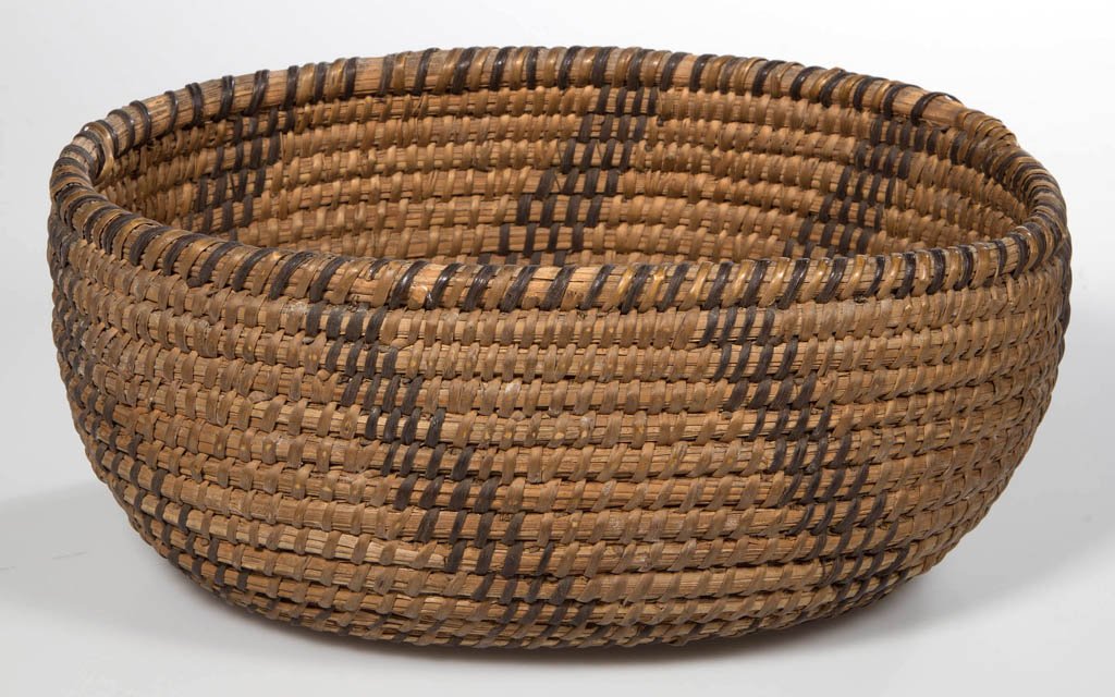 NATIVE AMERICAN WOVEN COILED BASKET: NATIVE AMERICAN WOVEN COILED BASKET, oval form with angled decoration. Late 19th/early 20th century. 4" H, 6 3/8" x 9".