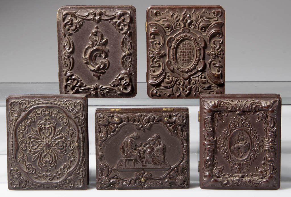 THERMOPLASTIC PHOTOGRAPH CASES, LOT OF FIVE: THERMOPLASTIC PHOTOGRAPH CASES, LOT OF FIVE, including one molded with a man and woman playing chess, and one with a strawberry in the reserve. Containing common ambrotype and tintype images. Third qu