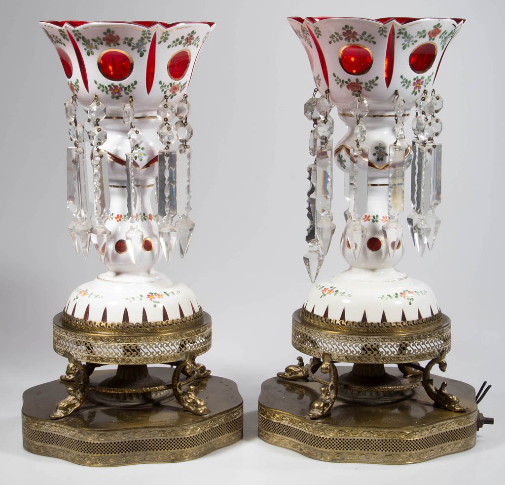 CONTINENTAL CUT OVERLAY PAIR OF MANTLE LUSTERS: CONTINENTAL CUT OVERLAY PAIR OF MANTLE LUSTERS, white cut to ruby with polychrome enamel decoration, each hung with prisms and mounted on a brass base, fitted with a small electric in bowl. One with a