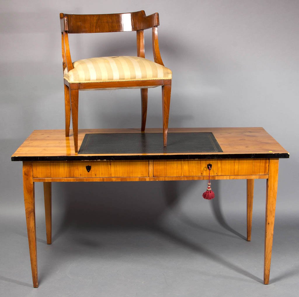 BIEDERMEIER WRITING DESK AND ARM CHAIR: BIEDERMEIER WRITING DESK AND ARM CHAIR, the desk with rectangular top fitted with later black leather panel and ebonized edge highlighting over two half-length drawers raised on square-tapered legs. P
