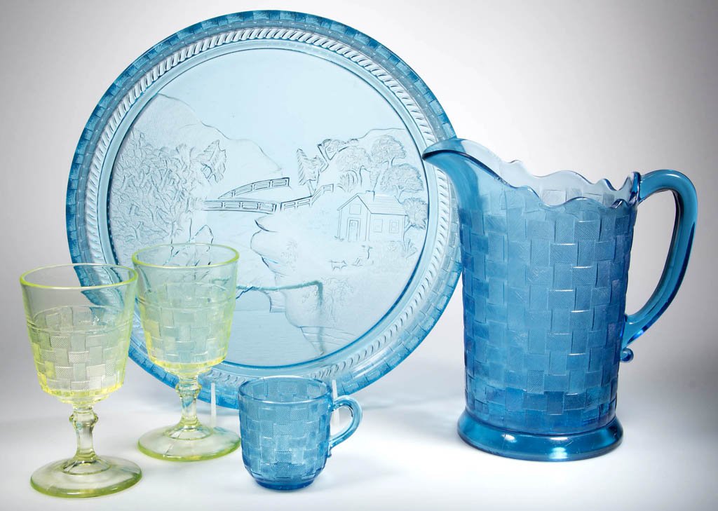 BASKETWEAVE TABLE ARTICLES, LOT OF FIVE: BASKETWEAVE TABLE ARTICLES, LOT OF FIVE, blue and vaseline (uranium), comprising a water pitcher, water tray, cup, and two goblets. Fourth quarter 19th century. 2 5/8" to 8 5/8" H, tray 12 1/8" D. Pro