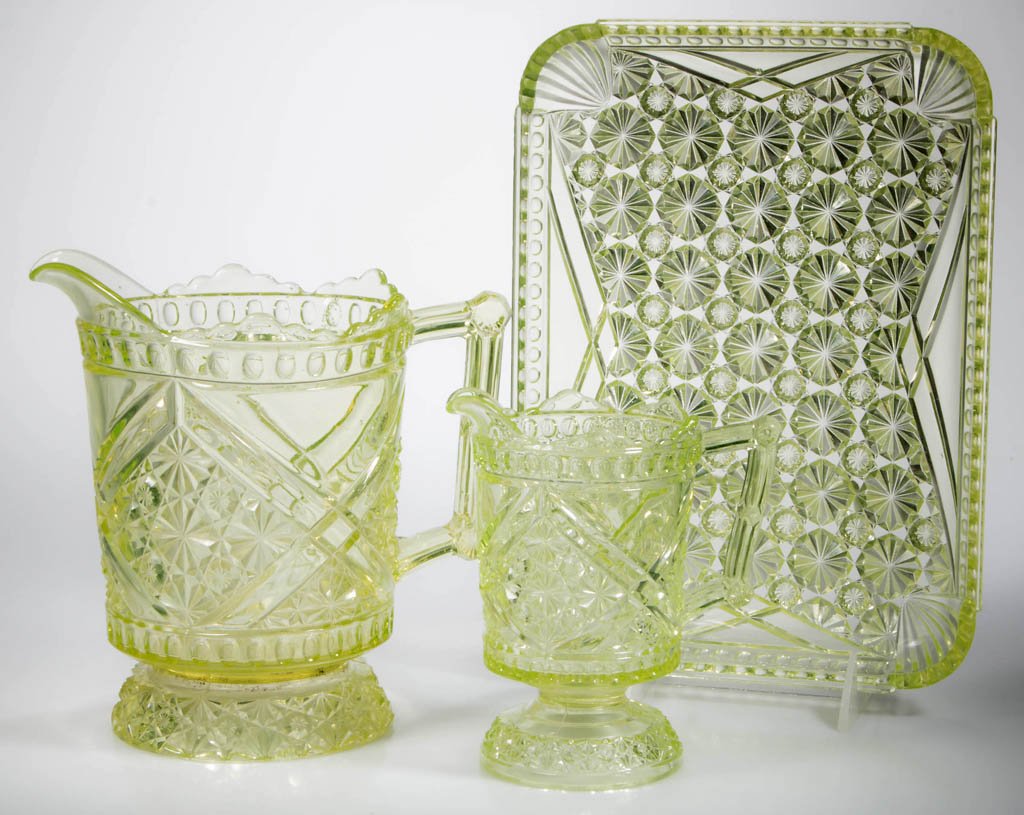 DAISY AND BUTTON WITH CROSSBARS / MIKADO TABLE: DAISY AND BUTTON WITH CROSSBARS / MIKADO TABLE ARTICLES, LOT OF THREE, vaseline (uranium), comprising a water pitcher, creamer, and tray. Fourth quarter 19th century. Tray 11" x 8". Provenance: From a