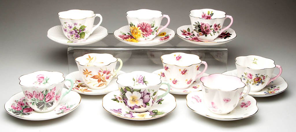 ENGLISH SHELLEY CHINA "DAINTY" SHAPE CUP AND SAUCERS: ENGLISH SHELLEY CHINA "DAINTY" SHAPE CUP AND SAUCERS SETS, LOT OF NINE, white, with printed polychrome decoration, assorted patterns, including "Baileys Sweet Pea", "Baileys Pink Rhododendron", and "M