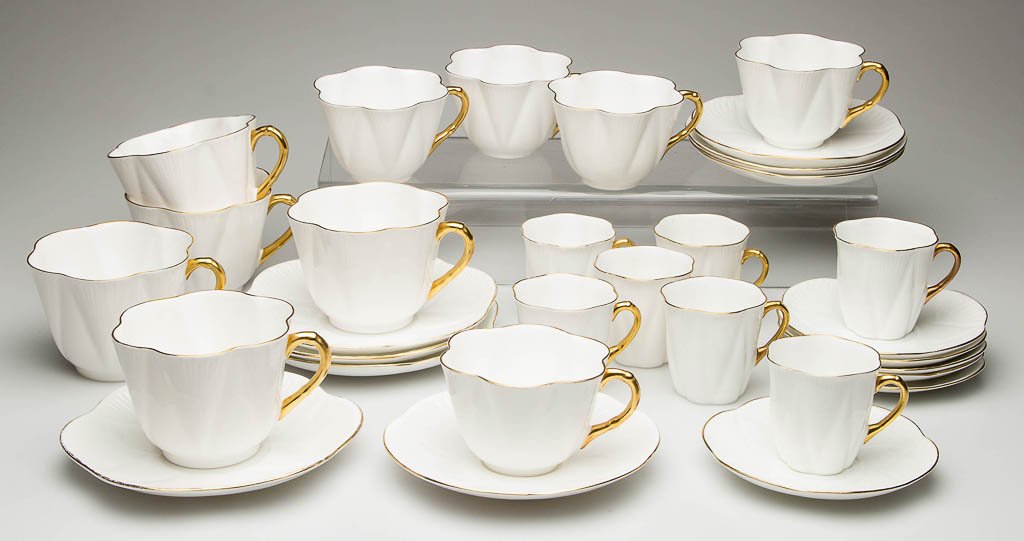 ENGLISH SHELLEY CHINA "DAINTY" SHAPE "REGENCY" PATTERN: ENGLISH SHELLEY CHINA "DAINTY" SHAPE "REGENCY" PATTERN TEA ARTICLES, LOT OF 31, white with gilt rims and handles, composite sets, comprising seven demitasse cups and six saucers, five large coffee cup
