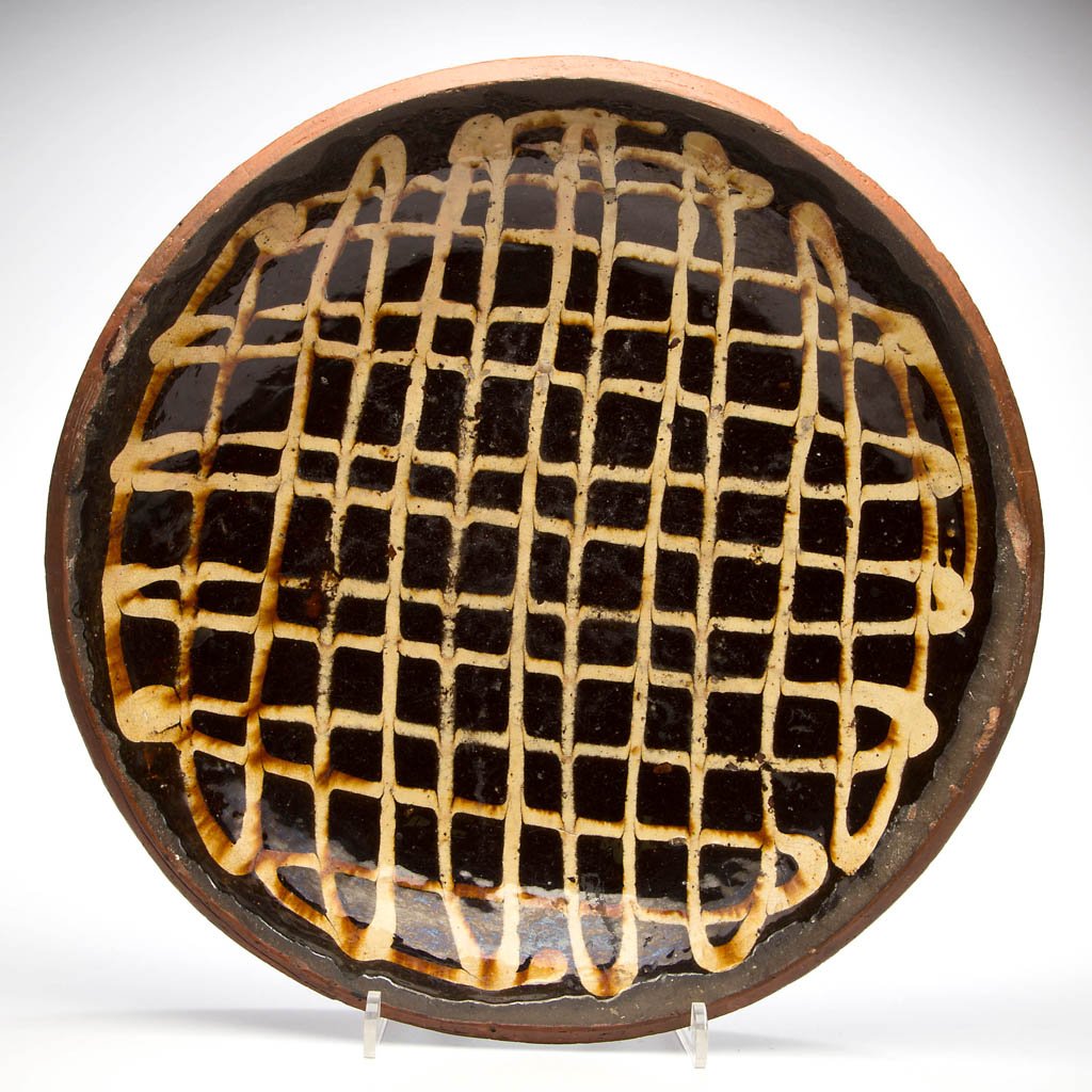 ENGLISH SLIP-DECORATED EARTHENWARE / REDWARE CHARGER: ENGLISH SLIP-DECORATED EARTHENWARE / REDWARE CHARGER, manganese- and lead-glazed, shallow form with plain rim, interior with cross-hatch slip decoration. Late 18th century. 3" H, 15 1/8" D. Provenance