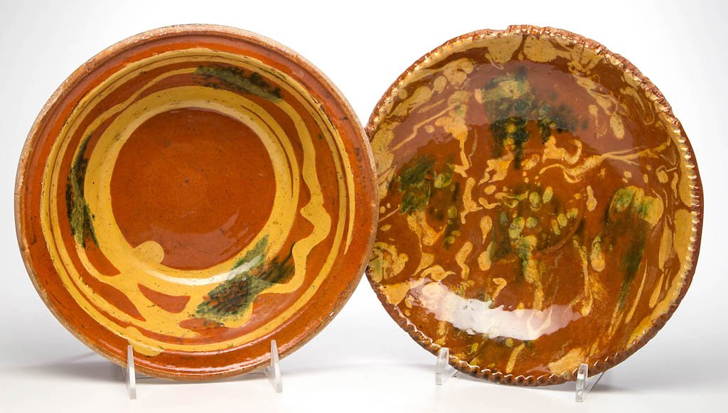 AMERICAN SLIP-DECORATED EARTHENWARE / REDWARE ARTICLES,: AMERICAN SLIP-DECORATED EARTHENWARE / REDWARE ARTICLES, LOT OF TWO, lead-glazed, comprising a bowl with plain rim and a plate with coggled rim, each center with yellow-slipped decorations and copper s