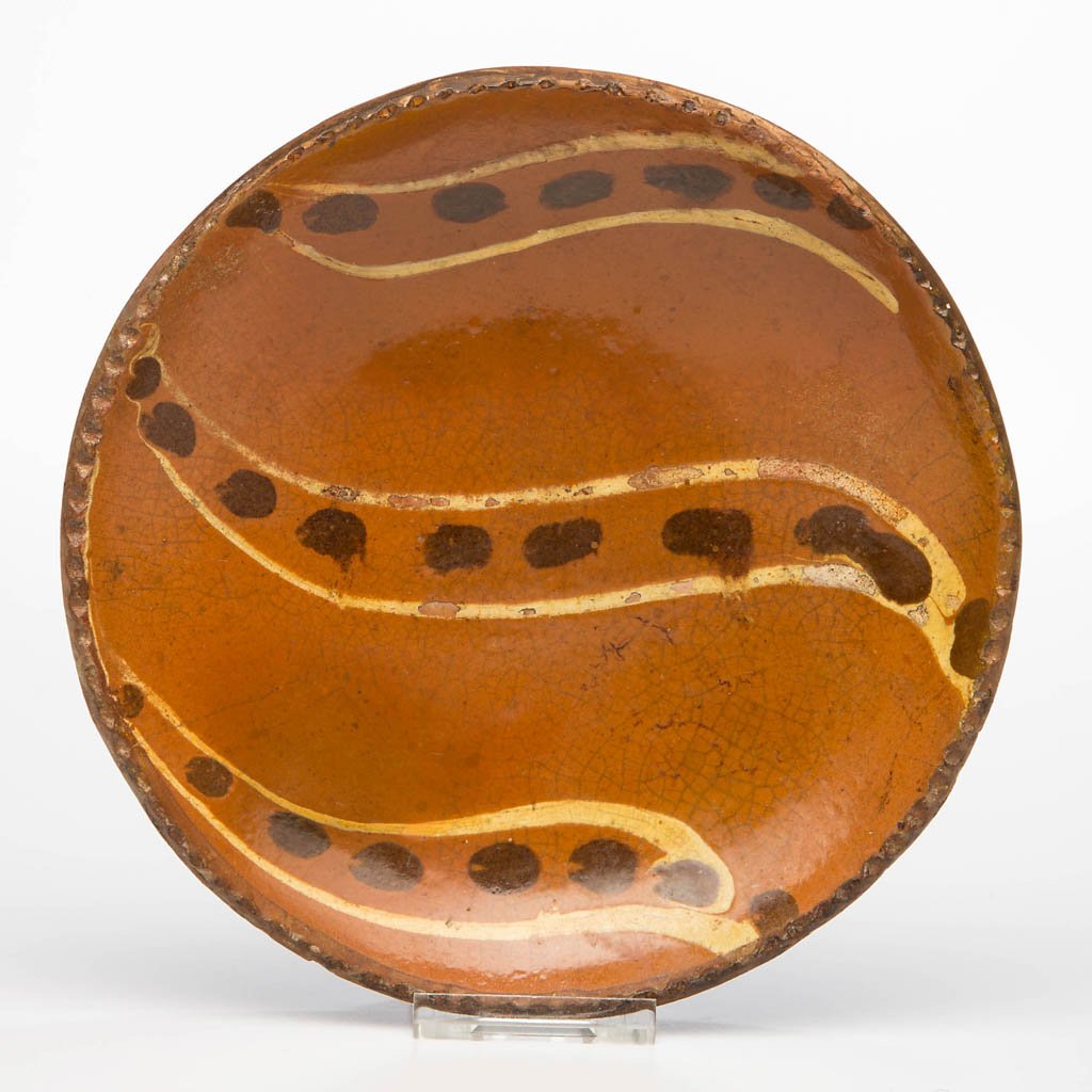 PENNSYLVANIA SLIP-DECORATED EARTHENWARE / REDWARE: PENNSYLVANIA SLIP-DECORATED EARTHENWARE / REDWARE DIMINUTIVE PLATE, lead-glazed, shallow form with lightly coggled rim, center with yellow-slipped and manganese-brushed "pea pod" decoration. First qua