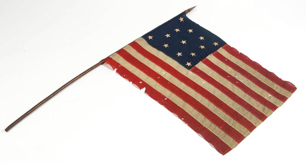 UNITED STATES 13-STAR FLAG: UNITED STATES 13-STAR CENTENNIAL FLAG, machine-stitched, on a hickory pole. Late 19th/early 20th century. 25" x 33", pole 53" L. Provenance: From the collection of Janet and the late Michael Parmer, W