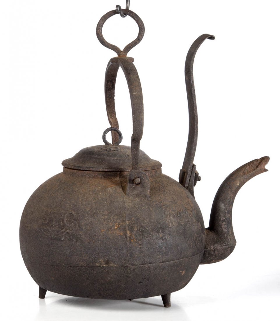 AMERICAN, PROBABLY SOUTH CAROLINA CAST-IRON TILTING: AMERICAN, PROBABLY SOUTH CAROLINA CAST-IRON TILTING KETTLE, bulbous body with goose-neck spout, bail handle with swivel ring hook, upright tilting bar, and original cover, the whole raised on three fe
