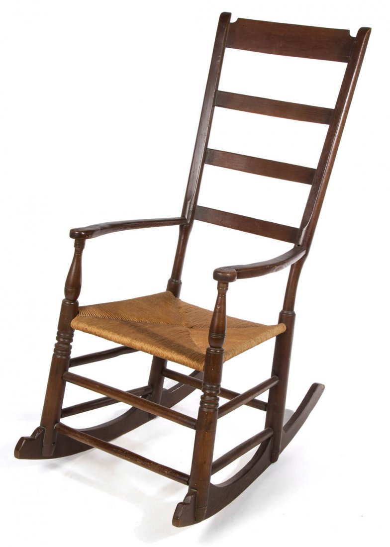 SHENANDOAH VALLEY OF VIRGINIA OAK LADDER-BACK ROCKING: SHENANDOAH VALLEY OF VIRGINIA OAK LADDER-BACK ROCKING ARM CHAIR, the four-slat back and shaped arm rests with baluster-form supports above woven-rush seat raised on ring-turned front legs and plain re