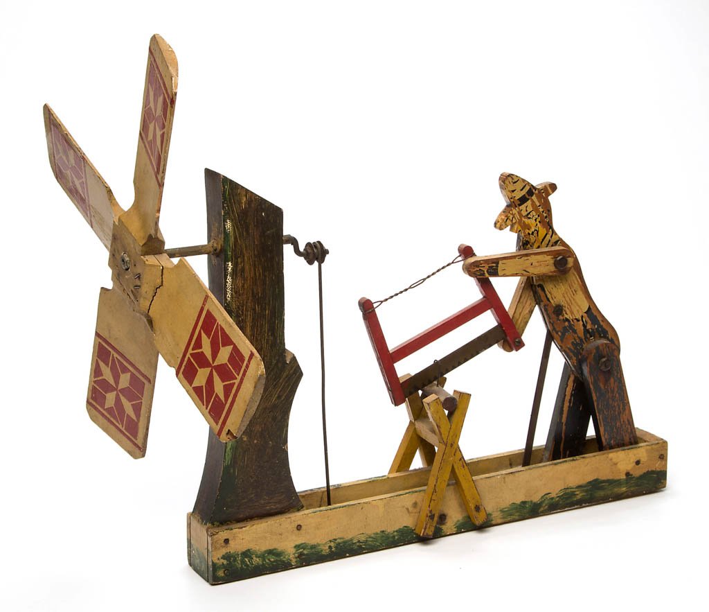 AMERICAN CUT-OUT AND PAINTED WOOD WHIRLIGIG: AMERICAN CUT-OUT AND PAINTED WOOD WHIRLIGIG, depicting a man with bucksaw cutting wood. Original polychrome painted surfaces. Labeled for the Falcon Wooden Novelties, Falconer, New York. Circa 1940. 1