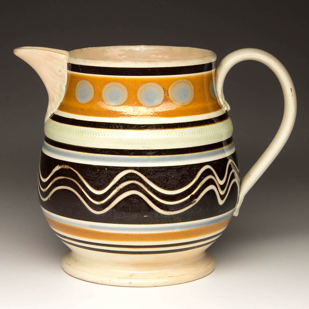 ENGLISH STAFFORDSHIRE POTTERY PEARLWARE MOCHAWARE: ENGLISH STAFFORDSHIRE POTTERY PEARLWARE MOCHAWARE PITCHER, squat baluster form, C-form strap handle with foliate terminals, raised herringbone-incised light green band at shoulder, dipped in shades of