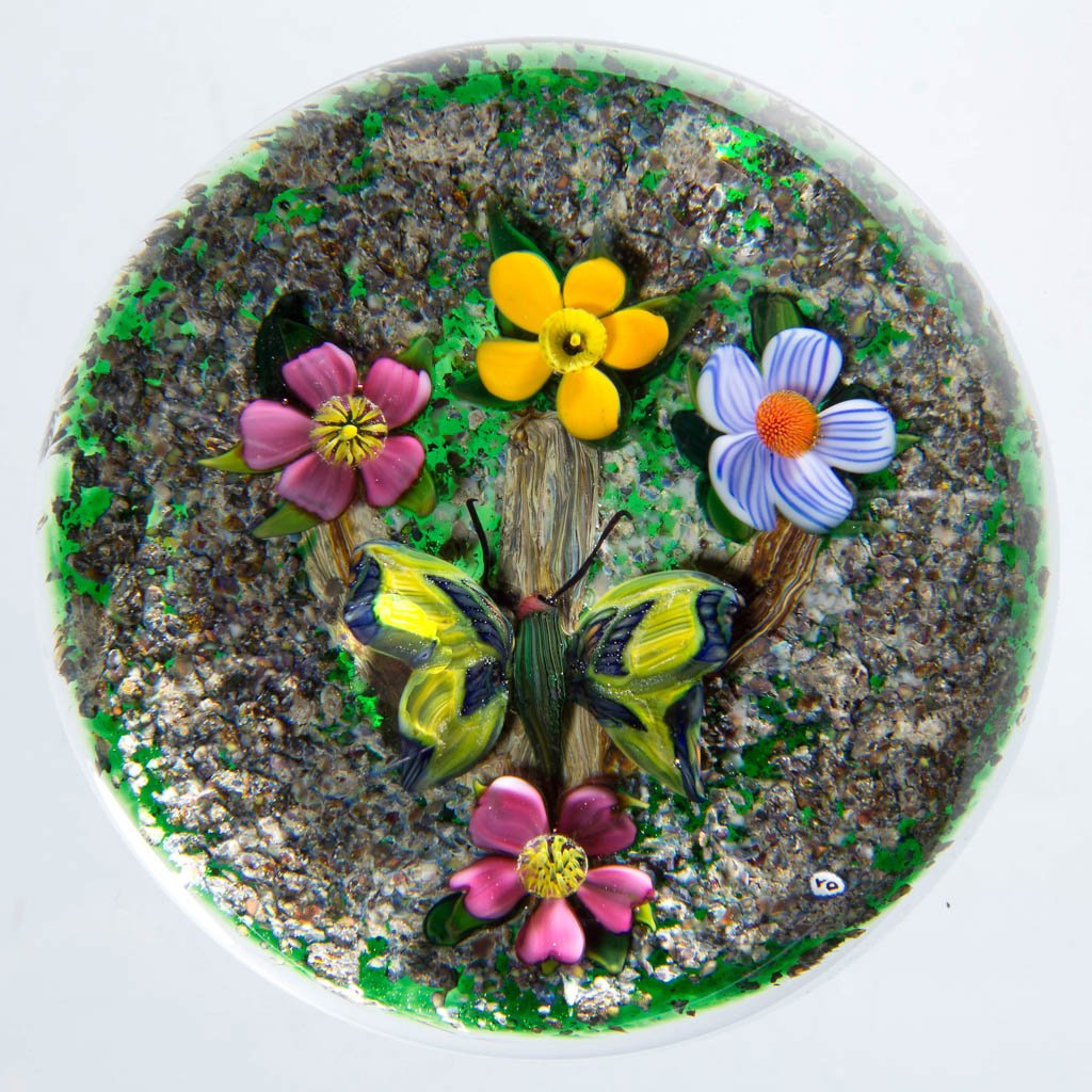 DEBBIE TARSITANO STUDIO ART GLASS LAMPWORK MAGNUM: DEBBIE TARSITANO STUDIO ART GLASS LAMPWORK MAGNUM PAPERWEIGHT, depicting a butterfly and flowers on a sand base, signature "DT" cane visible. Fourth quarter 20th century. 3 1/2" D. Provenance: From a 