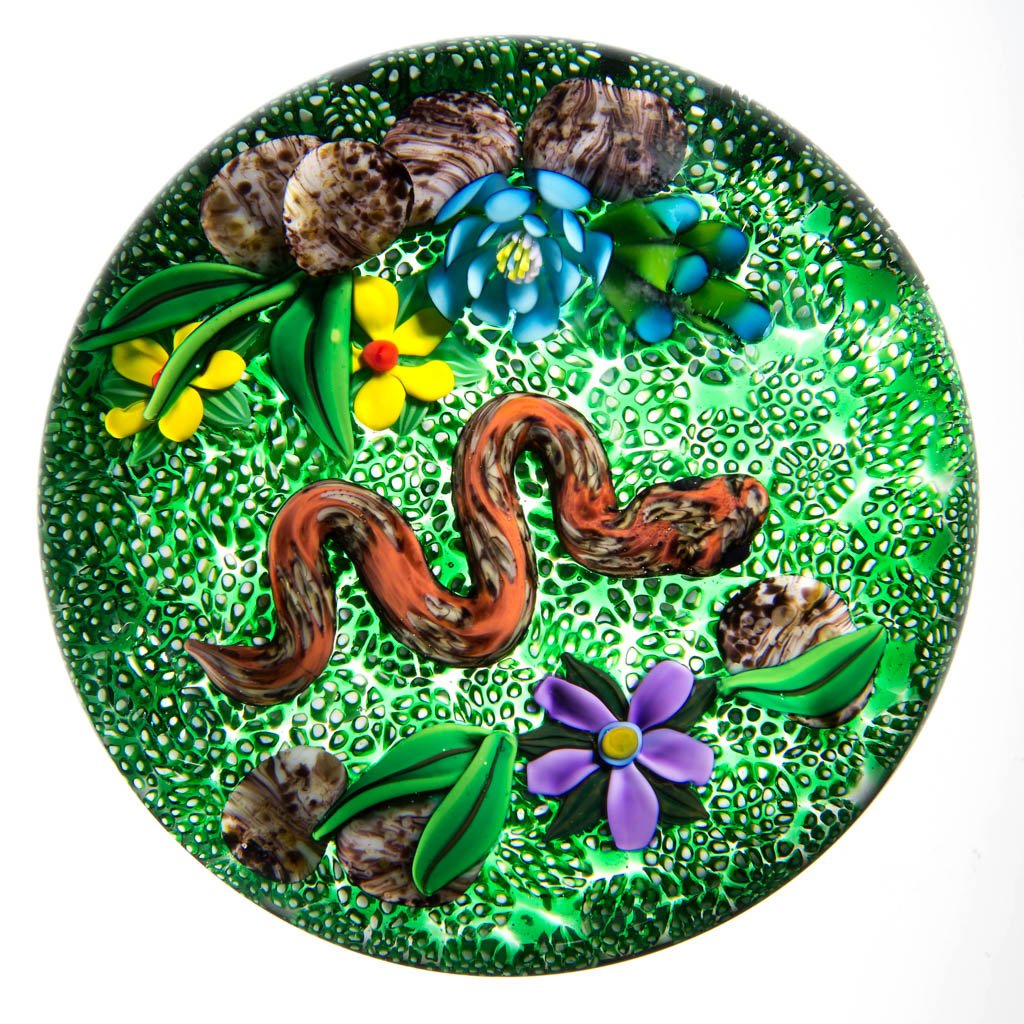 KEN ROSENFELD STUDIO ART GLASS LAMPWORK PAPERWEIGHT: KEN ROSENFELD STUDIO ART GLASS LAMPWORK PAPERWEIGHT, depicting flowers with snake, signed and dated, signature "R" cane visible. 1994. 3 1/4" D. Provenance: From a private collection.