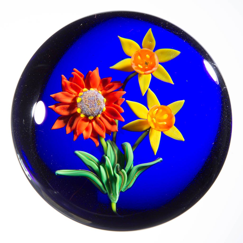 KEN ROSENFELD STUDIO ART GLASS LAMPWORK PAPERWEIGHT: KEN ROSENFELD STUDIO ART GLASS LAMPWORK PAPERWEIGHT, depicting jonquils on a blue background, signed and dated, signature "R" cane visible. 1996. 2 1/2" D. Provenance: From a private collection.