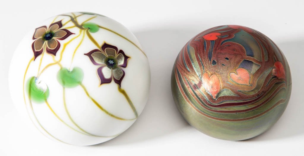 LUNDBERG STUDIOS ART GLASS PAPERWEIGHTS, LOT OF TWO: LUNDBERG STUDIOS ART GLASS PAPERWEIGHTS, LOT OF TWO, opaque white, comprising an iridized Heart and Vine, and a Daniel Salazar Flower and Vine weight. Salazar, Daniel. 1973 and 1975. Floral 3" D.