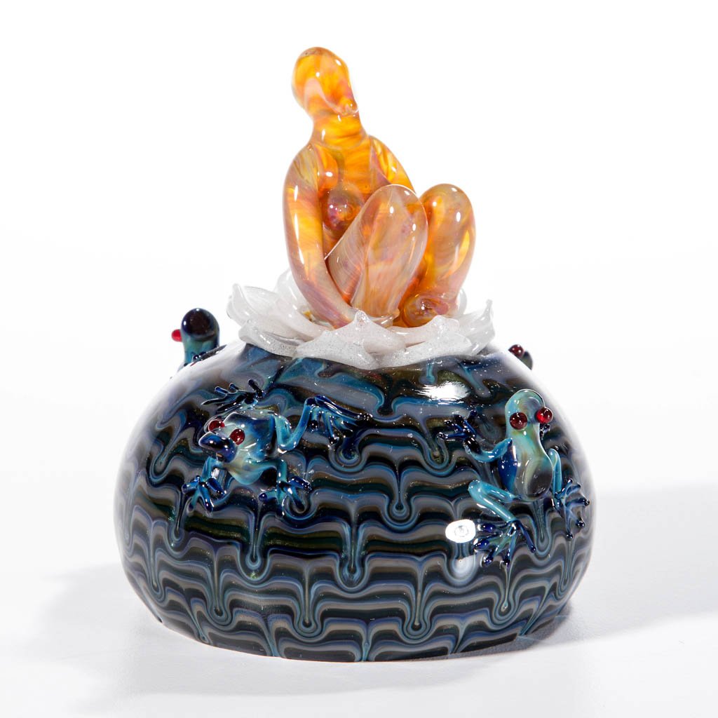 MILON TOWNSEND STUDIO ART GLASS PAPERWEIGHT: MILON TOWNSEND STUDIO ART GLASS PAPERWEIGHT, depicting four frogs surrounding a woman sitting on a lotus flower, signed and dated. 1998. 3 1/4" HOA, 3 1/2" DOA. Provenance: From a private collection.
