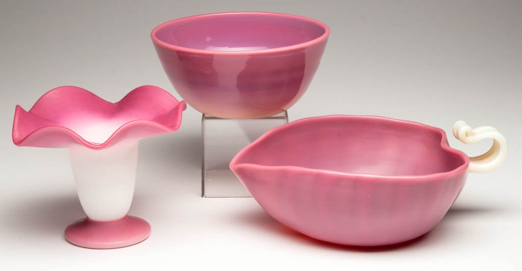 PAIRPOINT PEACHBLOW ARTICLES, LOT OF THREE: PAIRPOINT PEACHBLOW ARTICLES, LOT OF THREE, two with glossy and one with plush finish, comprising a leaf-form bowl with applied opalescent handle, a second bowl, and a flower-form vase. Gunderson-Pair
