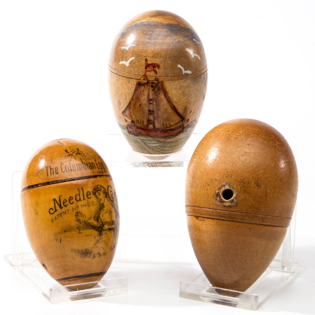 ASSORTED WOODEN EGG-FORM SEWING ARTICLES, LOT OF THREE: ASSORTED WOODEN EGG-FORM SEWING ARTICLES, LOT OF THREE, comprising a needle case marked "The Columbian Egg Needle Case Patent No 1492" and reverse "GIMBEL BROTHERS / NATION STORE / PHILADELPHIA / NEW-