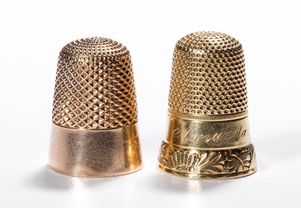 ASSORTED 14K GOLD THIMBLES, LOT OF TWO: ASSORTED 14K GOLD THIMBLES, LOT OF TWO, each tested 14K, comprising an example with a plain band over a stylized floral band and with name "Amanda"; and an unpatterned example. Weight: 9.0 grams total