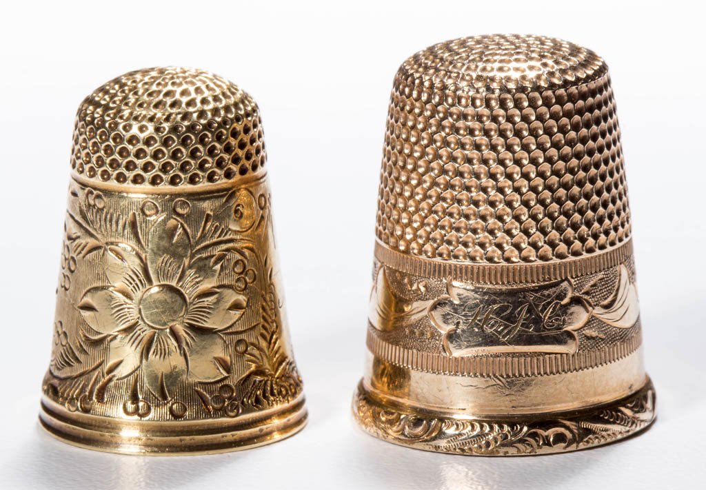 ASSORTED 14K GOLD THIMBLES, LOT OF TWO: ASSORTED 14K GOLD THIMBLES, LOT OF TWO, each tested 14k, comprising an example with a wide floral band and an example with a plain band between a floral band and a small scroll band, each divided by a