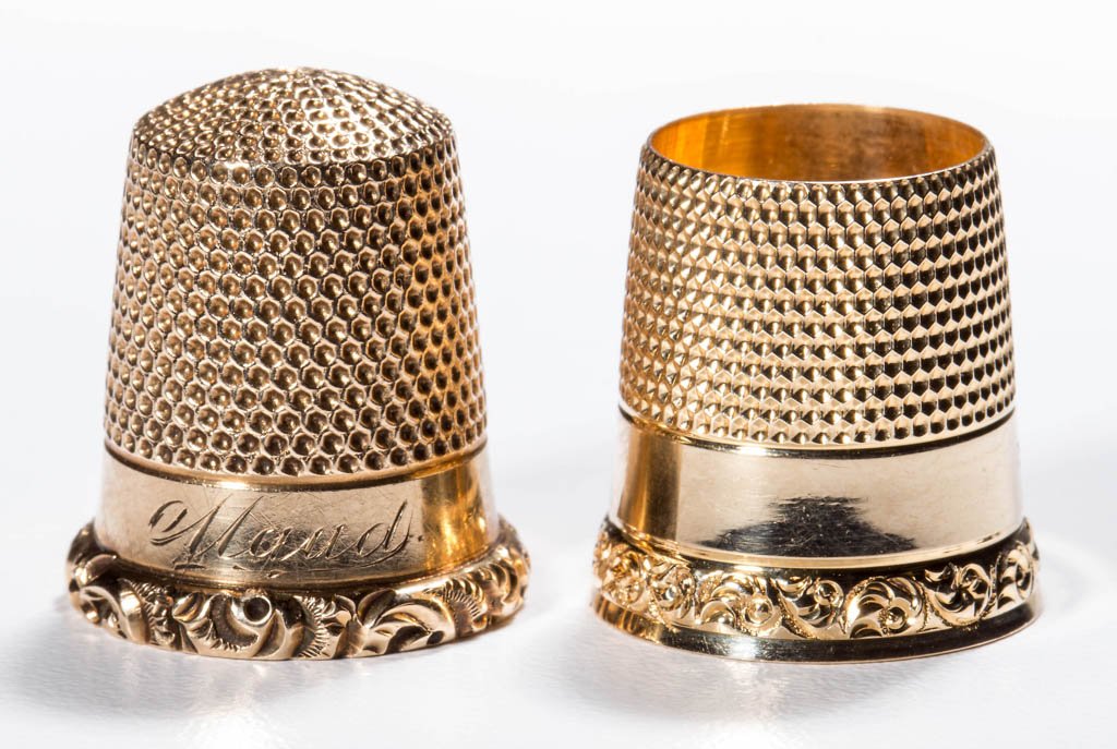ASSORTED 14K GOLD THIMBLES, LOT OF TWO: ASSORTED 14K GOLD THIMBLES, LOT OF TWO, comprising a tailor's example and an example with name "Maud", each with a narrow scroll rim and marked "14K" to the interior. Weight: 8.3 grams total. Late 19t