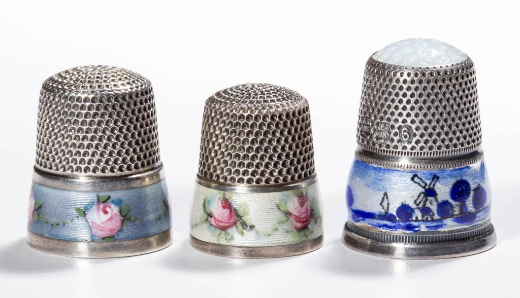 ENAMEL ON STERLING SILVER THIMBLES, LOT OF THREE: ENAMEL ON STERLING SILVER THIMBLES, LOT OF THREE, comprising two examples with a delicate rose pattern on a light blue and other with a light green band, and a blue and white Dutch scene German exampl