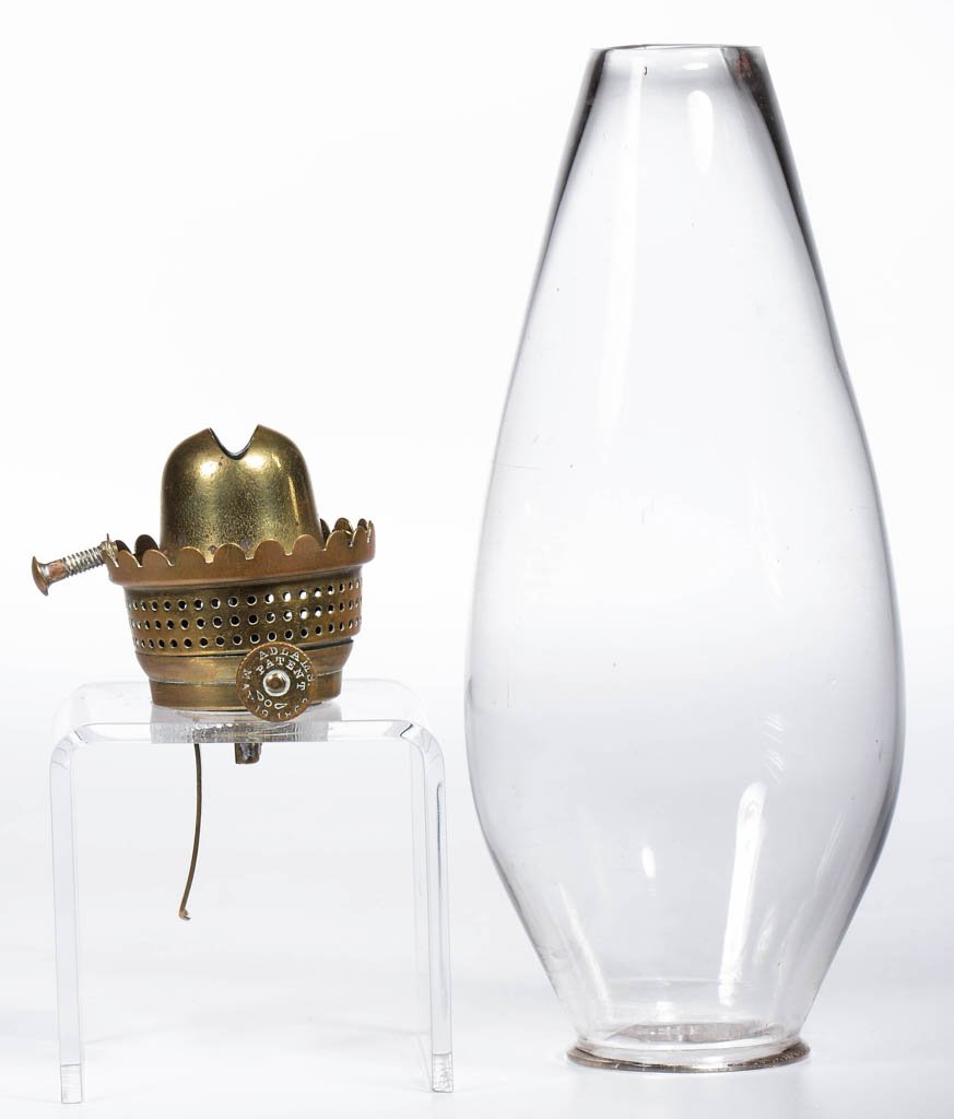 ADLAMS NO. 0 LIP BURNER AND CHIMNEY SETUP: ADLAMS NO. 0 LIP BURNER AND CHIMNEY SETUP, thumbwheel marked "ADLAMS. PATENT MAY 19. 1863" and with wing symbol, period colorless lip chimney. Third quarter 19th century. Chimney 5 3/4" H. Literature: