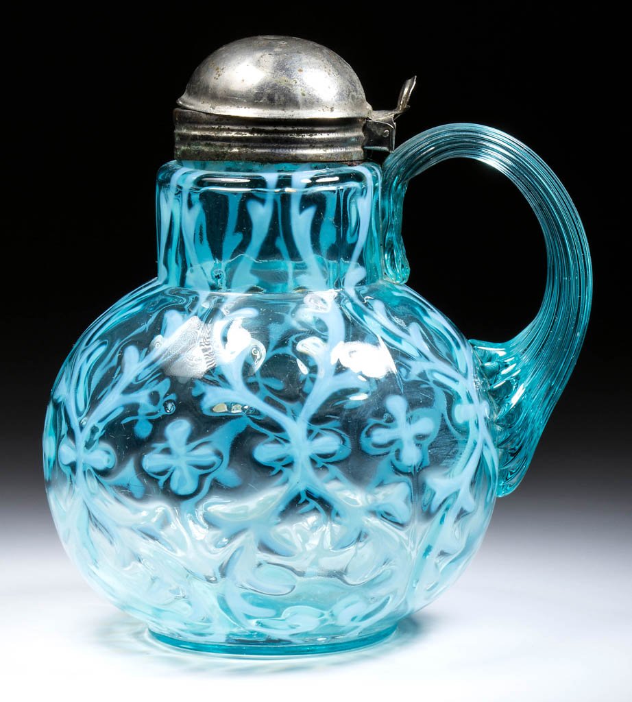 OPALINE BROCADE / SPANISH LACE - BALL-SHAPE MOULD SYRUP: OPALINE BROCADE / SPANISH LACE - BALL-SHAPE MOULD SYRUP PITCHER, blue opalescent, applied blue reeded handle, period lid. Late 19th/early 20th century. 5 7/8" H. Literature: Parallels Heacock/Elmore -