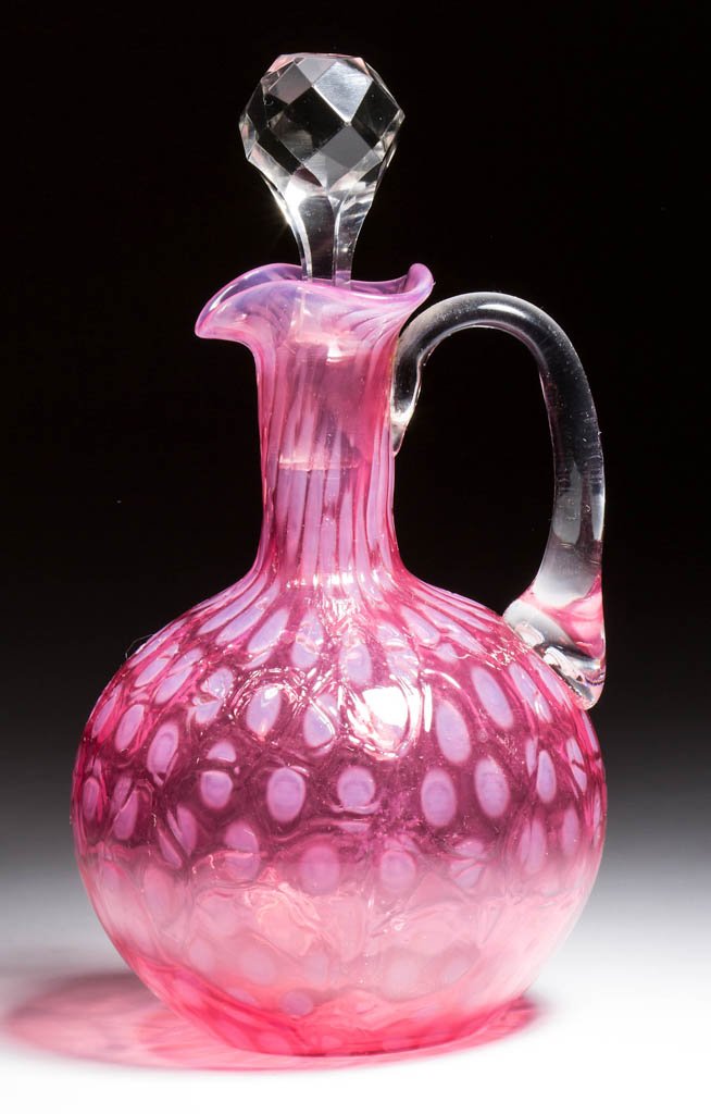 PHOENIX SPOT-OPTIC CRAQUELLE CRUET: PHOENIX SPOT-OPTIC CRAQUELLE CRUET, cranberry opalescent, ball-form with triangular ruffled rim, applied colorless handle, polished pontil mark. Phoenix Glass Co. Circa 1883-1888. 6 1/2" HOA. Literatu