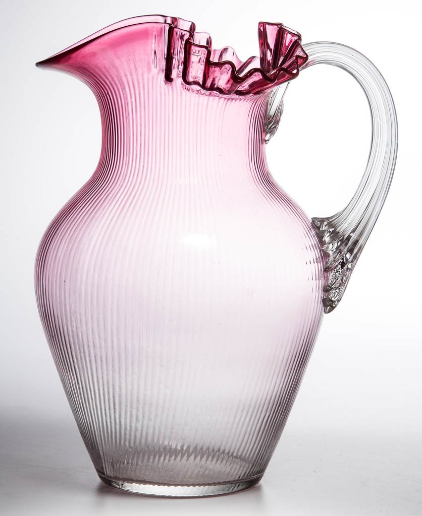 PHOENIX FINE RIB WATER PITCHER: PHOENIX FINE RIB WATER PITCHER, rubina, shoulder mold with duckbill crimped rim, applied colorless reeded handle, polished pontil mark. Phoenix Glass Co. Circa 1883-1888. 9 3/4" H. Literature: Marple 