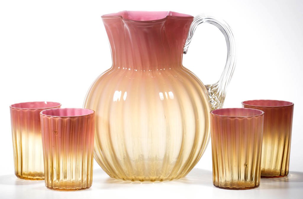HEAVY RIB-OPTIC FIVE-PIECE WATER SET: HEAVY RIB-OPTIC FIVE-PIECE WATER SET, cased peach shaded to pale amber, comprising a bulbous pitcher with four-lobe top, applied colorless reeded handle, and polished pontil mark; and four tumblers wi