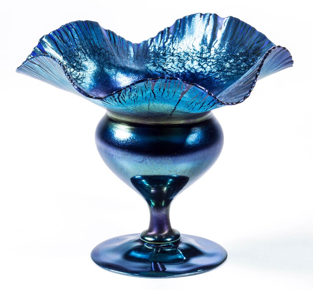 TIFFANY FAVRILE FLOWER FORM CABINET VASE: TIFFANY FAVRILE FLOWER FORM CABINET VASE, blue iridescent, having an applied foot with polished base and pontil mark, signed "2964 H/L.C.Tiffany-Favrile." Tiffany Studios. Circa1913. 4 1/2" HOA, 6" DO