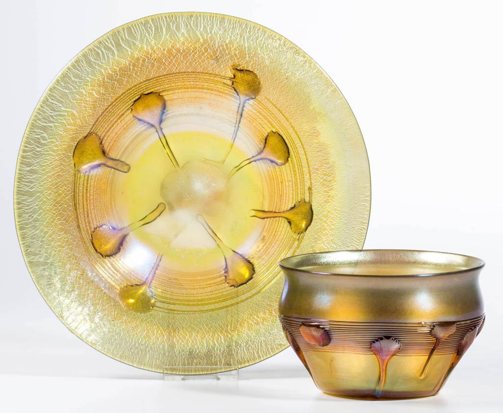 TIFFANY FAVRILE LILLY PAD TABLE ARTICLES, LOT OF TWO: TIFFANY FAVRILE LILLY PAD TABLE ARTICLES, LOT OF TWO, golden iridescent with strong green tint, comprising a finger bowl and plate, each with applied gold lily pads and threading, polished pontil mark