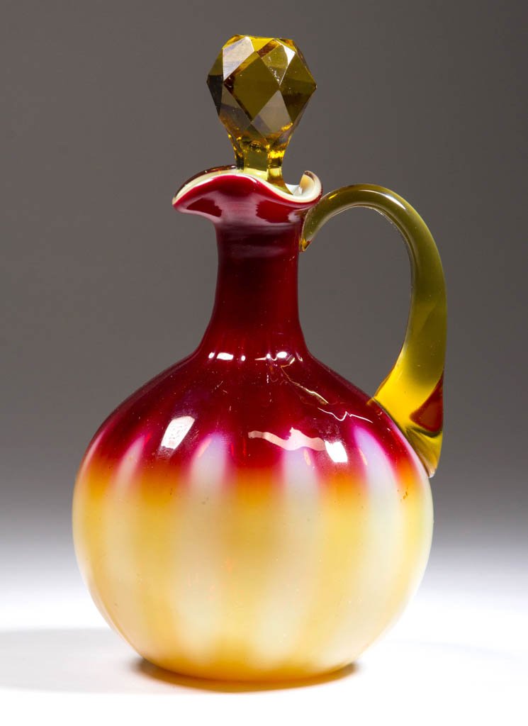 PLATED AMBERINA CRUET / OIL BOTTLE: PLATED AMBERINA CRUET / OIL BOTTLE, opal cased deep maroon fuchsia to pale amber, globular-form molded with 12 vertical ribs, tri-corner mouth, applied pale amber handle, original facet-cut pale amber