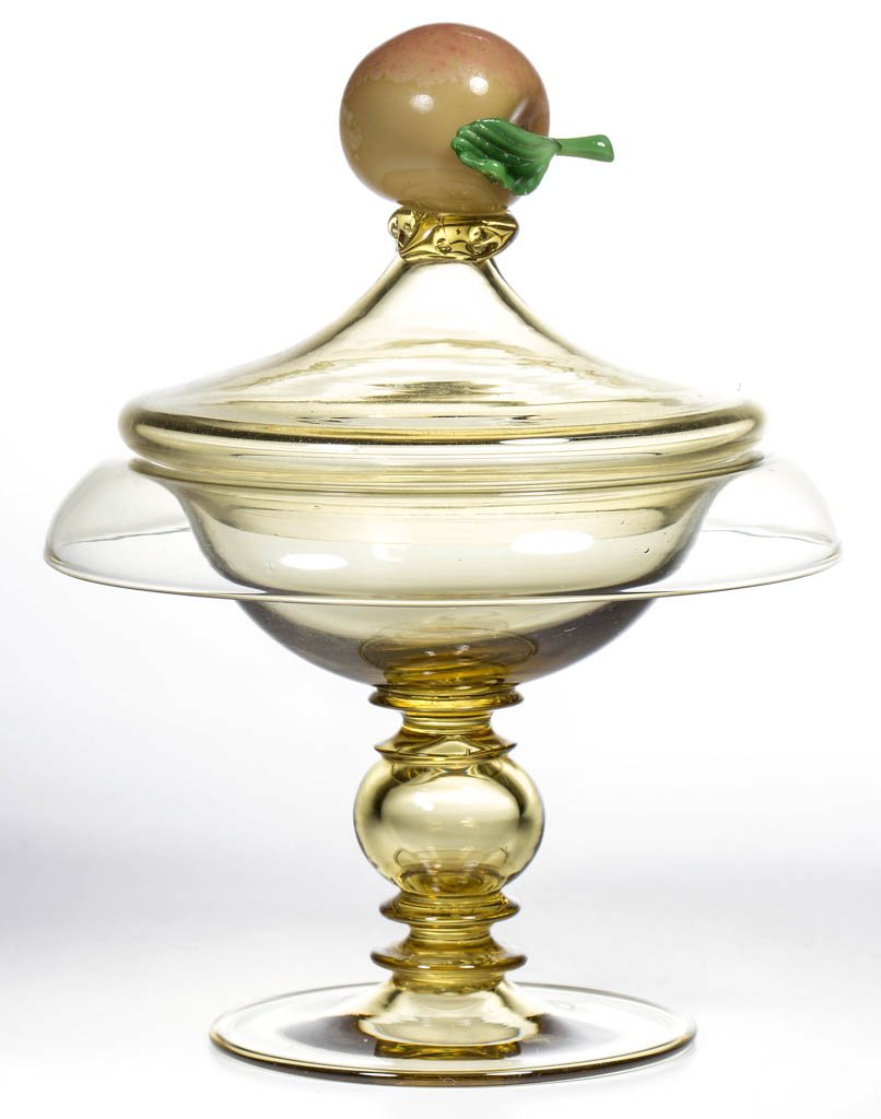 STEUBEN ART GLASS COVERED COMPOTE: STEUBEN ART GLASS COVERED COMPOTE, Topaz, compote with rolled-over rim, hollow-knop stem, and rough pontil mark, cover having an apple-form finial with green stem and leaf, unsigned. Steuben Glass Wor