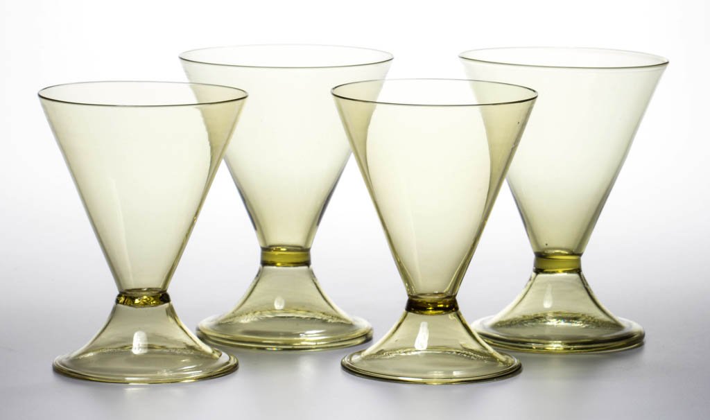 STEUBEN ART GLASS GOBLETS, LOT OF FOUR: STEUBEN ART GLASS GOBLETS, LOT OF FOUR, Amber, each conical form with applied foot and polished pontil mark. Steuben Glass Works. Circa 1920-1930. 4 5/8" to 4 7/8" H. Provenance: From the collection o