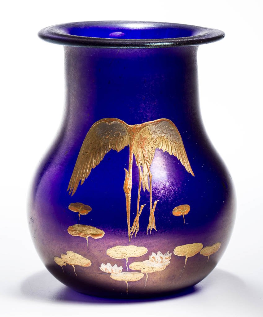 LOETZ-TYPE ART GLASS VASE: LOETZ-TYPE ART GLASS VASE, deep cobalt iridescent, heavy gilt decoration depicting a heron and pond lilies, polished pontil mark. Late 19th/early 20th century. 7 1/4" H, 5" D rim.