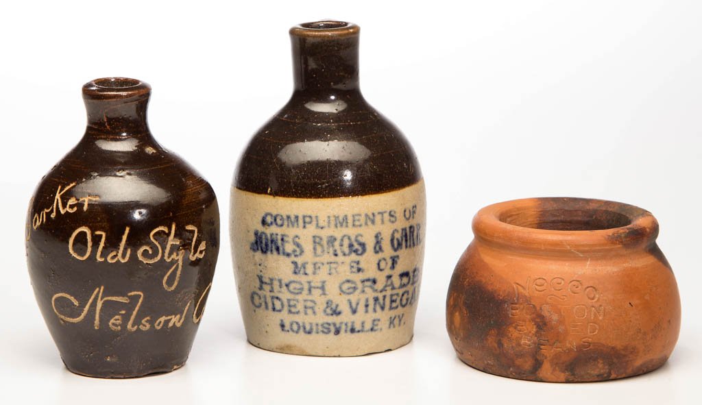 ADVERTISING STONEWARE MOTTO JUGS, LOT OF TWO: ADVERTISING STONEWARE MOTTO JUGS, LOT OF TWO, comprising an Albany-slip glazed example incised "R. H. Parker / Old Style / Nelson Co." and glazed under base, and a brown and white example stamped in b