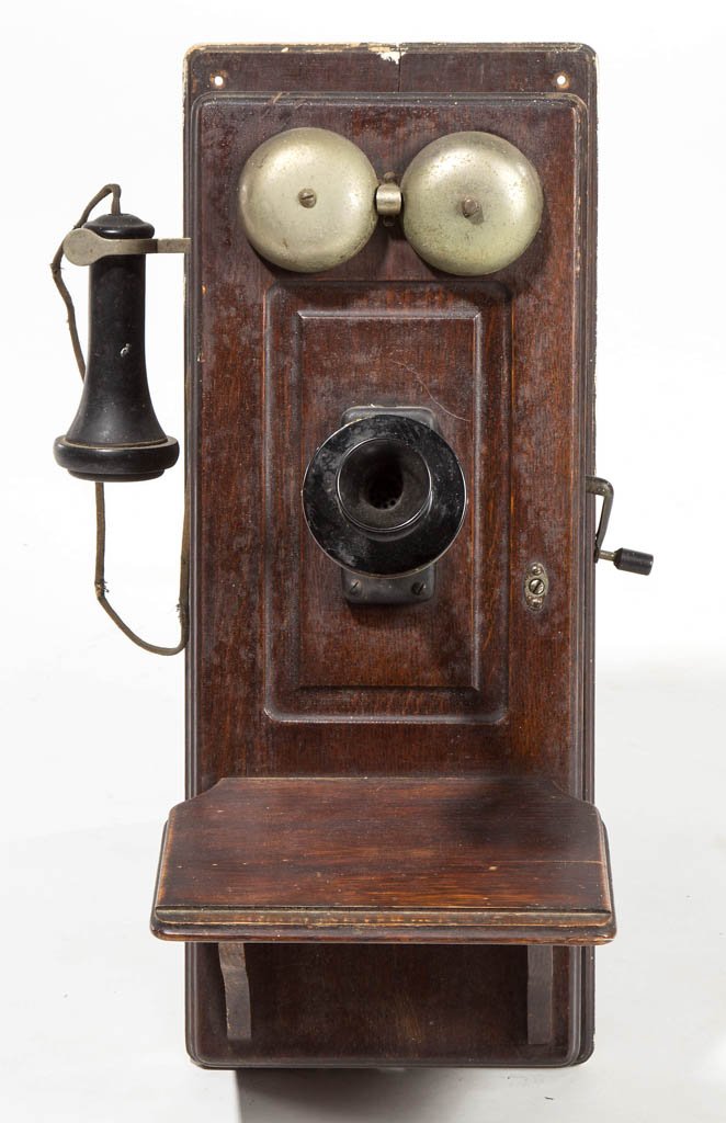 VINTAGE OAK WALL-MOUNT TELEPHONE: VINTAGE OAK WALL-MOUNT TELEPHONE, with original shelf, earpiece, crank, and double-bell ringer. Case with possibly original surface and in rich, dark color. Circa 1920. 23" H, 12" WOA, 14 1/2" DOA. Pr